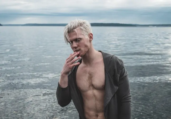 man with wet blonde hair at the beach