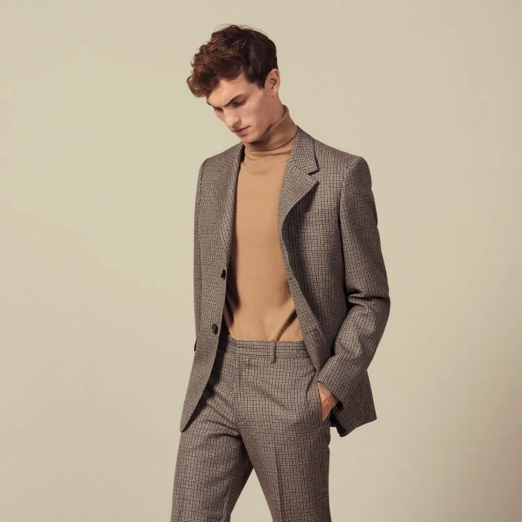 A man wearing a Sandro brown checkered cocktail suit