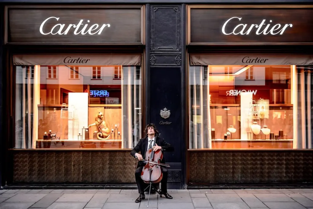 Man sitting in front of Cartier shop waiting for Men Fragrances