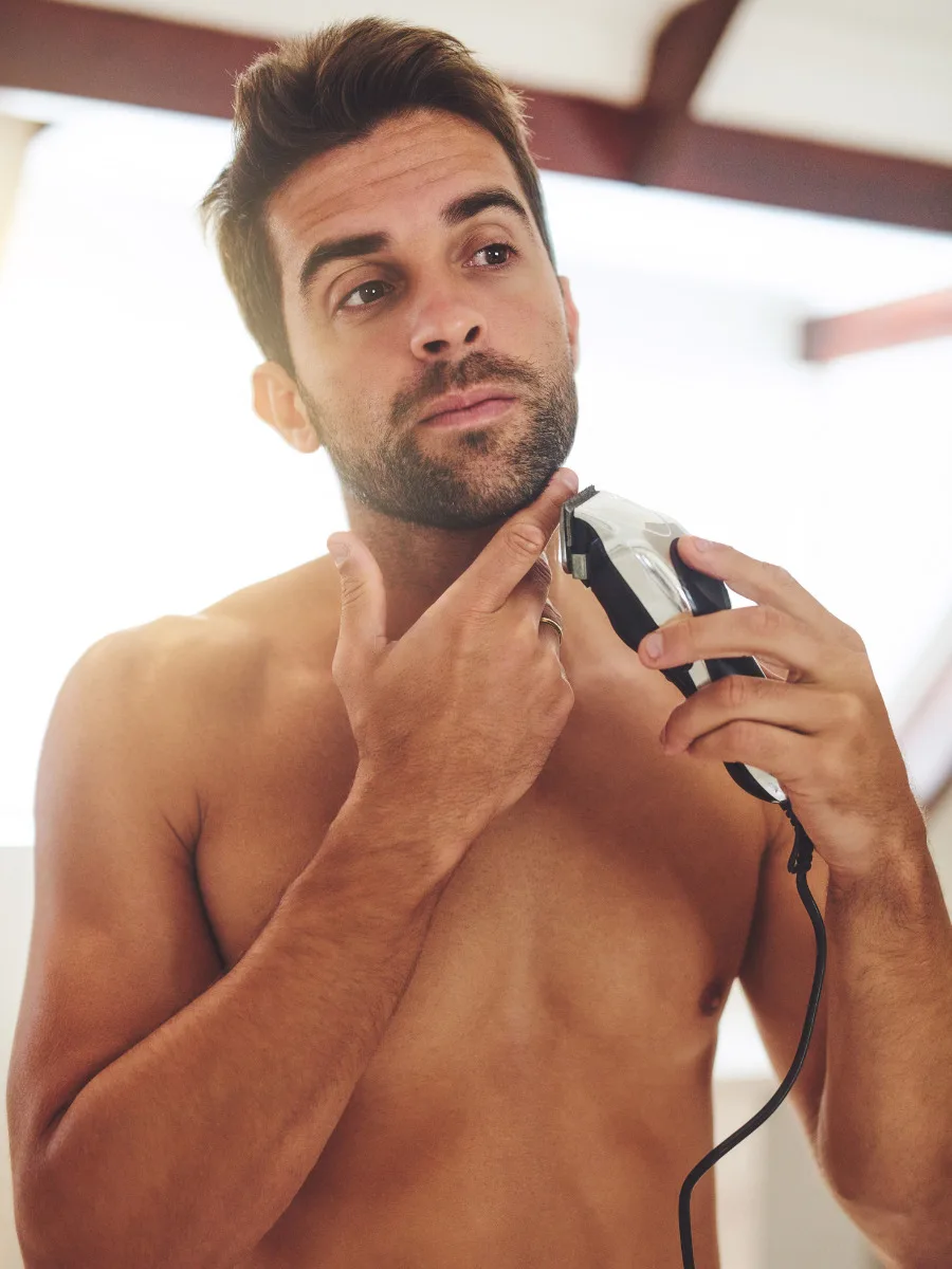 man trimming beard line